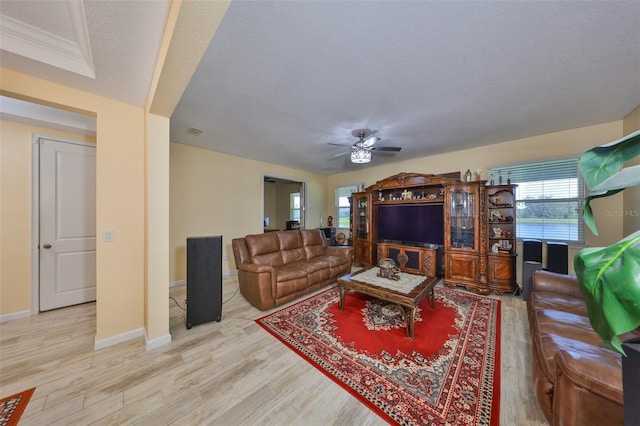 living room with visible vents, a textured ceiling, wood finished floors, baseboards, and ceiling fan