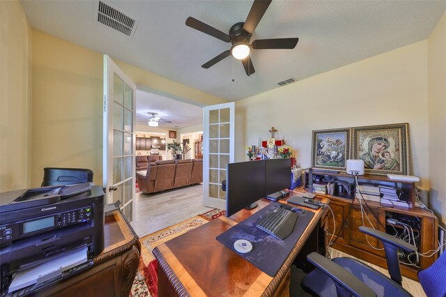 office featuring visible vents, french doors, a ceiling fan, and wood finished floors