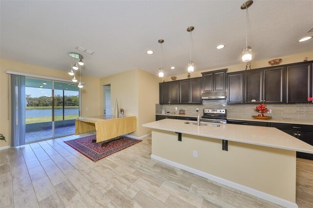 kitchen featuring visible vents, backsplash, a breakfast bar, and light countertops