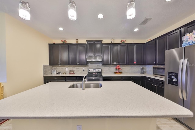 kitchen featuring visible vents, under cabinet range hood, decorative backsplash, stainless steel appliances, and a sink