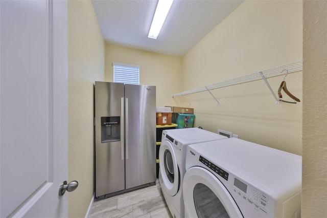 washroom featuring a textured ceiling, laundry area, and washer and clothes dryer