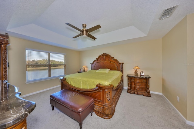 carpeted bedroom featuring visible vents, a raised ceiling, a textured ceiling, and baseboards