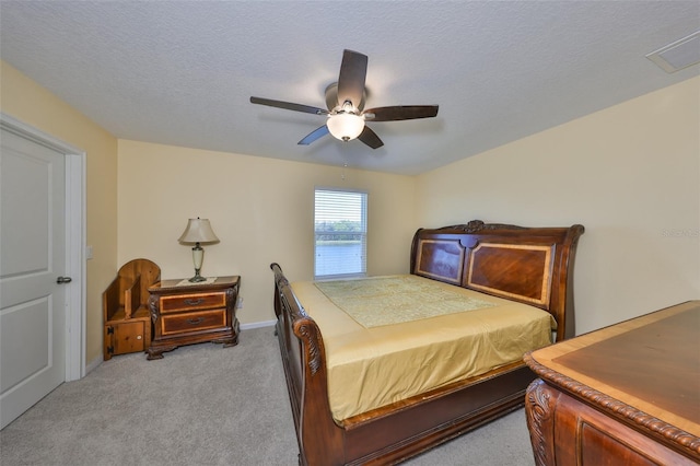 bedroom featuring a ceiling fan, baseboards, visible vents, a textured ceiling, and light carpet