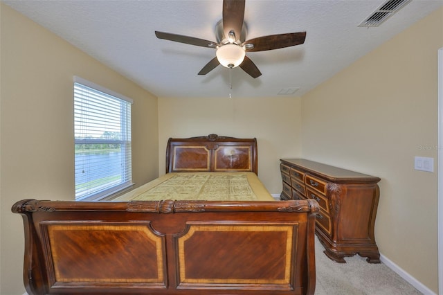 carpeted bedroom featuring visible vents, baseboards, and a ceiling fan