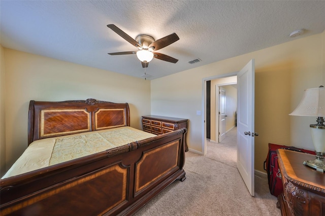 bedroom featuring visible vents, baseboards, ceiling fan, light colored carpet, and a textured ceiling