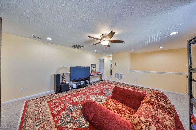 living area featuring baseboards, visible vents, carpet floors, and ceiling fan