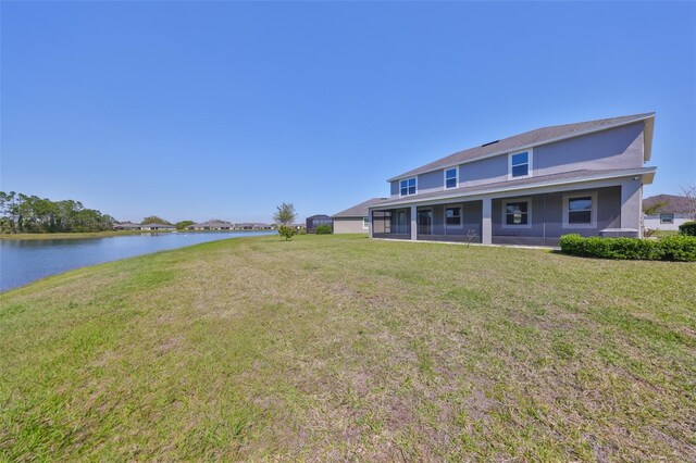 back of property featuring a yard and a water view