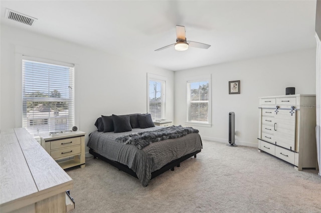 bedroom featuring ceiling fan, baseboards, visible vents, and light carpet