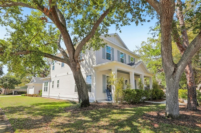 view of front of home with board and batten siding, covered porch, and a front lawn