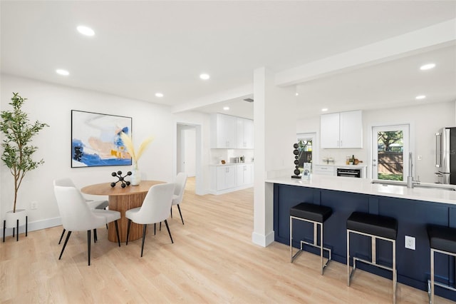 dining room featuring recessed lighting, light wood-type flooring, and baseboards