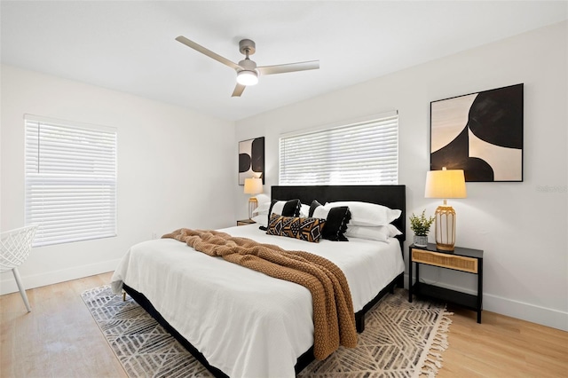 bedroom featuring light wood-type flooring, baseboards, and a ceiling fan