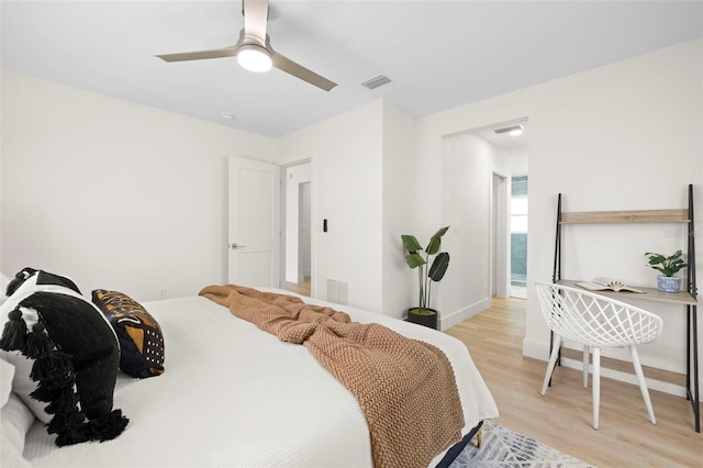 bedroom featuring light wood-type flooring, visible vents, baseboards, and ceiling fan