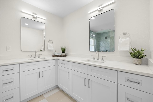 full bathroom with a shower stall, double vanity, tile patterned floors, and a sink