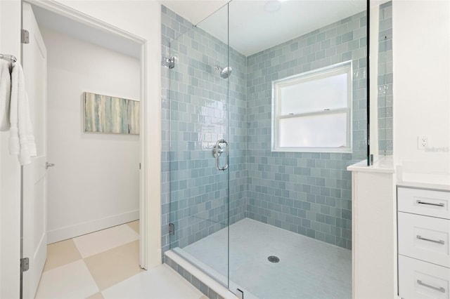 bathroom with vanity, a shower stall, baseboards, and tile patterned floors