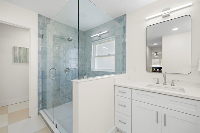 full bathroom featuring vanity, baseboards, and a stall shower