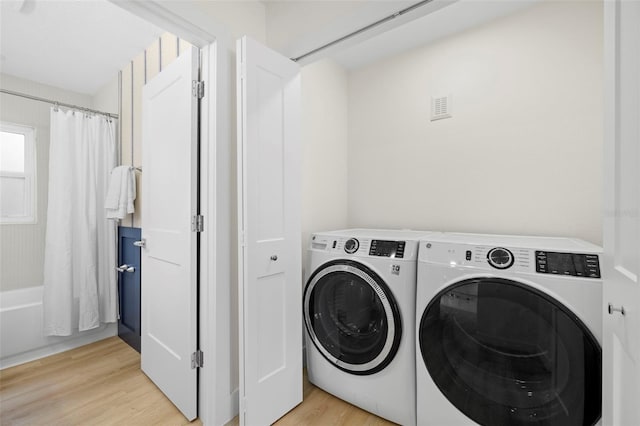 laundry room with light wood-style flooring, laundry area, and washing machine and clothes dryer