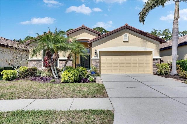 mediterranean / spanish-style home with stucco siding, stone siding, and driveway