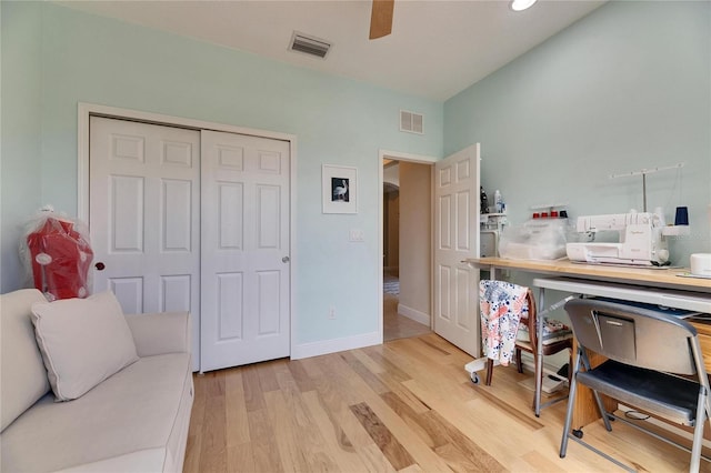 office featuring light wood finished floors, visible vents, baseboards, and a ceiling fan