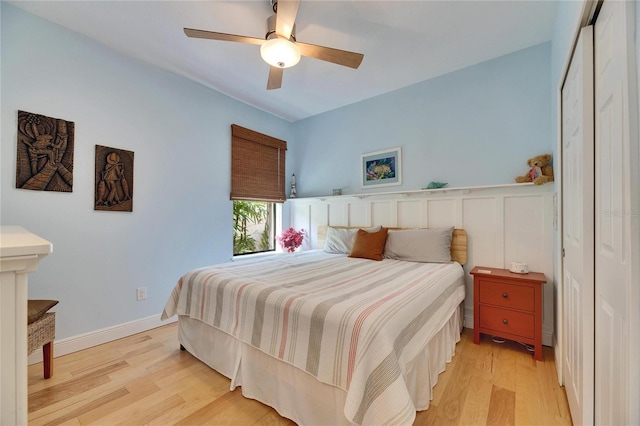 bedroom featuring light wood-type flooring, baseboards, and a ceiling fan