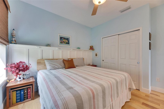 bedroom featuring visible vents, a ceiling fan, a closet, light wood finished floors, and baseboards