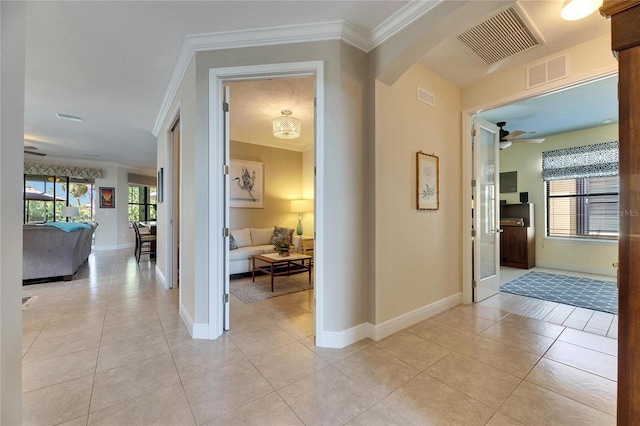 corridor featuring light tile patterned floors, visible vents, and ornamental molding