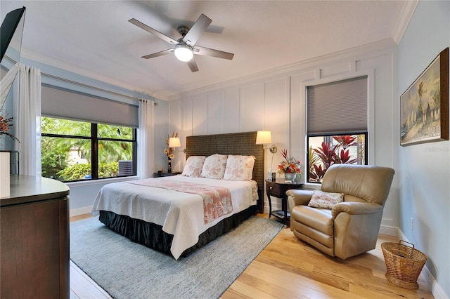 bedroom with ceiling fan, light wood-style flooring, baseboards, and ornamental molding