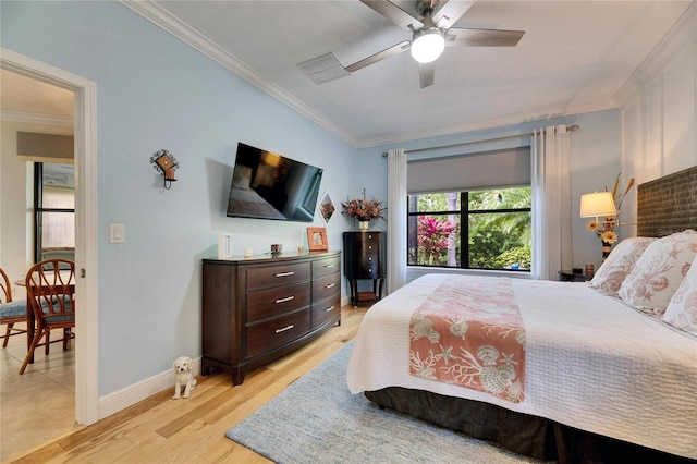 bedroom with a ceiling fan, crown molding, light wood-style floors, and baseboards