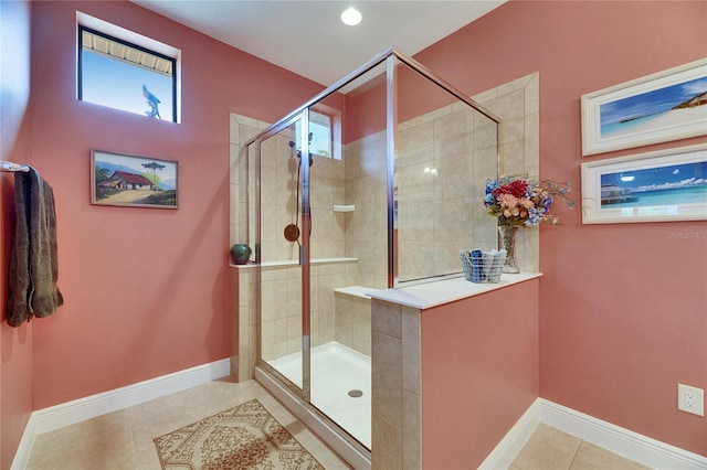 bathroom with tile patterned floors, a shower stall, and baseboards