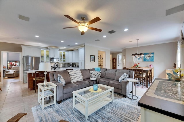 living area featuring visible vents, crown molding, light tile patterned floors, recessed lighting, and ceiling fan with notable chandelier