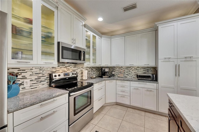 kitchen with visible vents, light tile patterned flooring, decorative backsplash, white cabinets, and appliances with stainless steel finishes