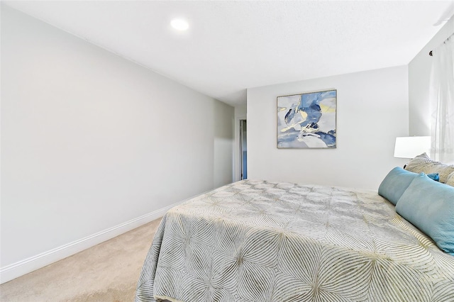 bedroom featuring baseboards and light carpet