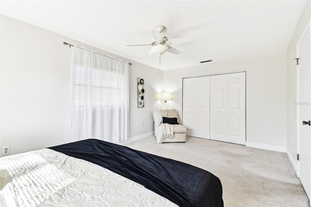 carpeted bedroom featuring visible vents, baseboards, a textured ceiling, and a closet
