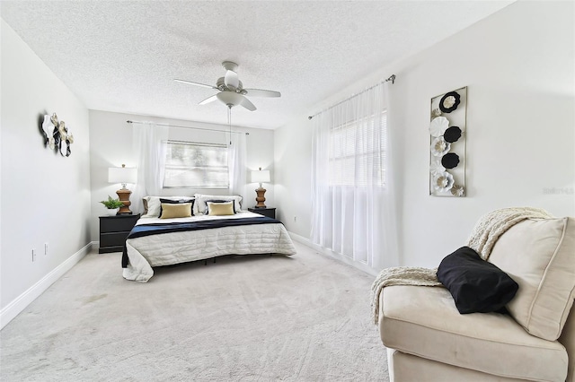 bedroom with multiple windows, carpet, baseboards, and a textured ceiling