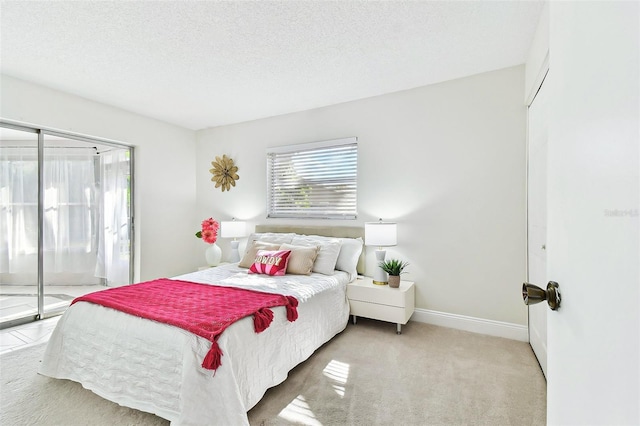 carpeted bedroom with a textured ceiling, baseboards, and access to outside