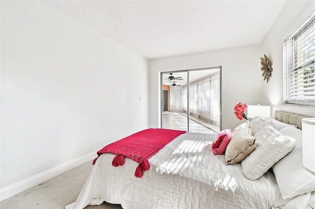 carpeted bedroom with a closet, a textured ceiling, and baseboards