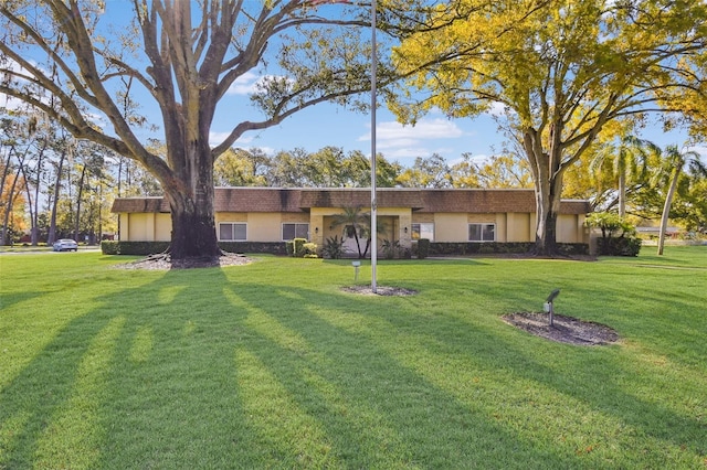 view of front facade with a front yard and stucco siding