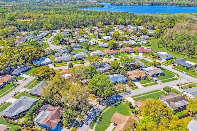 drone / aerial view with a residential view, a water view, and a view of trees