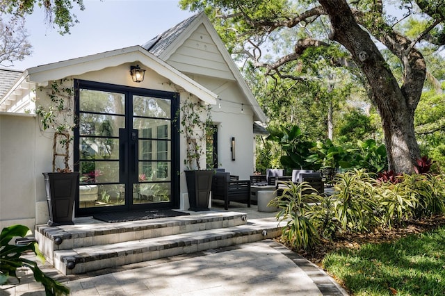 doorway to property featuring french doors and stucco siding