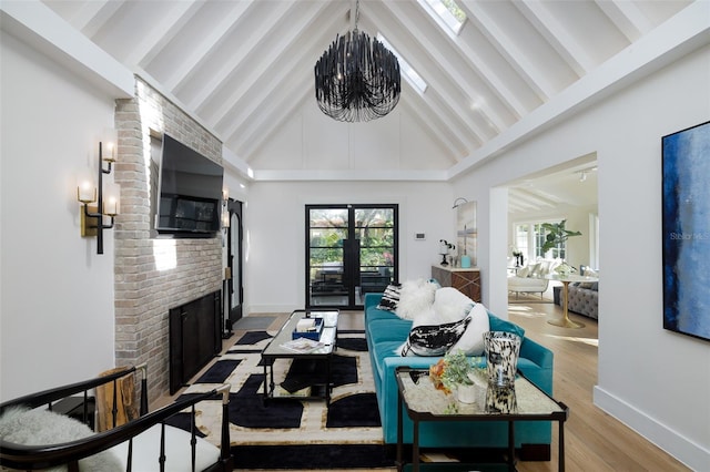living area featuring wood finished floors, high vaulted ceiling, an inviting chandelier, a fireplace, and beamed ceiling