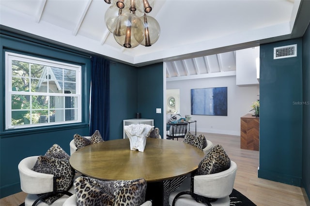 dining area with visible vents, beamed ceiling, a notable chandelier, light wood-style floors, and baseboards