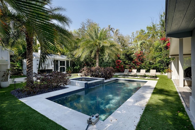 view of swimming pool featuring a patio area, a pool with connected hot tub, an outdoor structure, and a yard