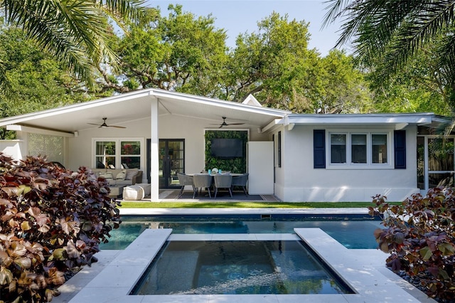 rear view of house with a patio area, stucco siding, an in ground hot tub, and ceiling fan