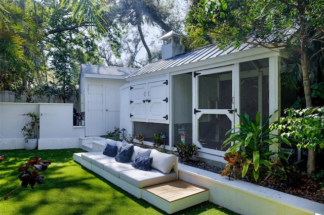 view of patio with an outdoor living space, an outbuilding, and fence