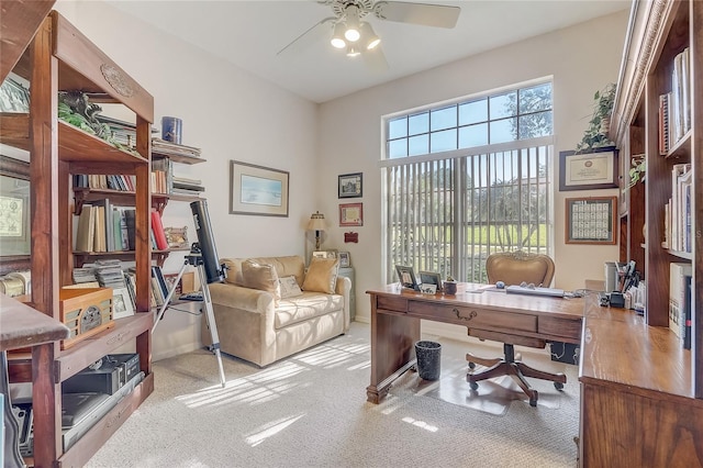 carpeted office space with a ceiling fan