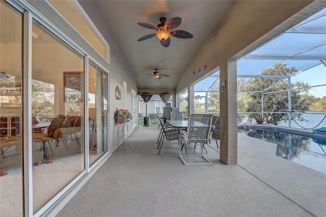 view of patio / terrace featuring glass enclosure, outdoor dining area, a ceiling fan, and an outdoor pool