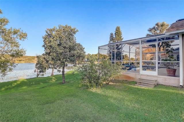 view of yard with glass enclosure and a water view