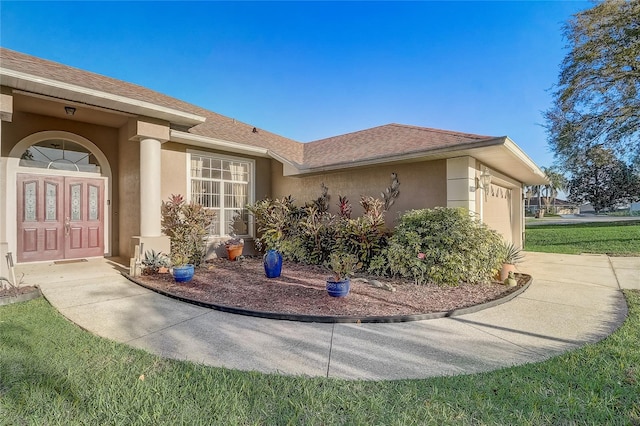 exterior space with stucco siding, an attached garage, a shingled roof, and concrete driveway