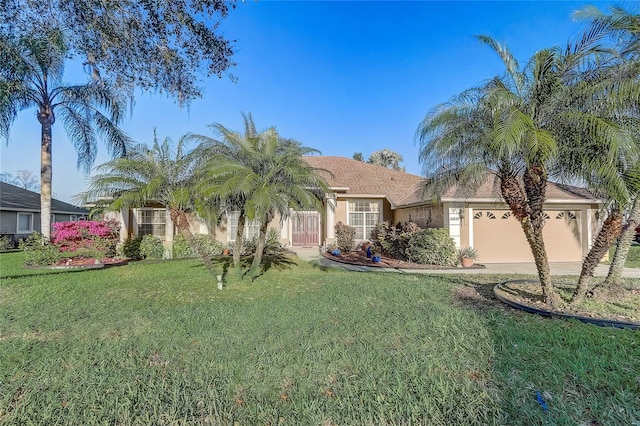 view of front facade with a garage, stucco siding, a front lawn, and driveway