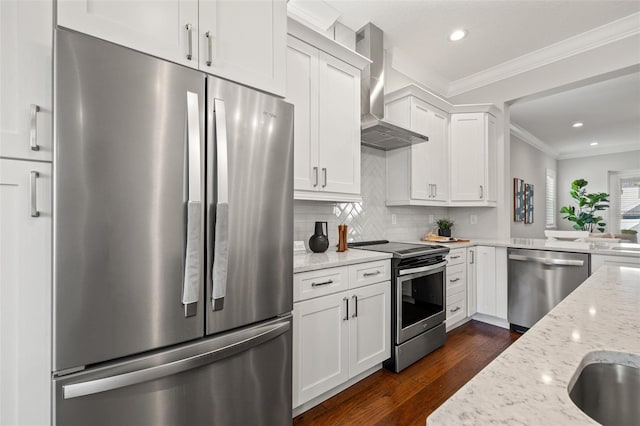 445 29th Ave N, Saint Petersburg, FL 33704 - kitchen featuring appliances with stainless steel finishes, wall chimney range hood, crown molding, white cabinets, and dark wood-style floors
