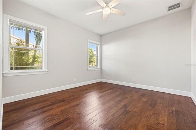 445 29th Ave N, Saint Petersburg, FL 33704 - empty room with healthy amount of natural light, baseboards, and dark wood-type flooring